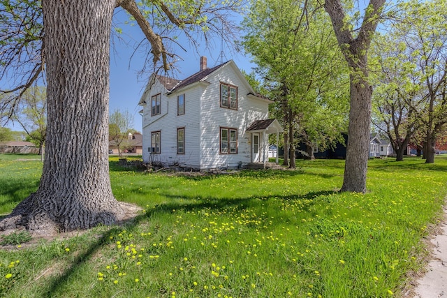 414 4th St, Winthrop, MN 55396 - view of property exterior featuring a chimney and a lawn
