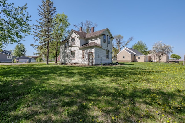 414 4th St, Winthrop, MN 55396 - rear view of property featuring a chimney and a lawn
