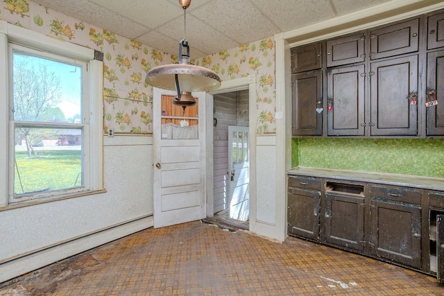 414 4th St, Winthrop, MN 55396 - kitchen with wallpapered walls, a drop ceiling, dark brown cabinets, a baseboard radiator, and light countertops