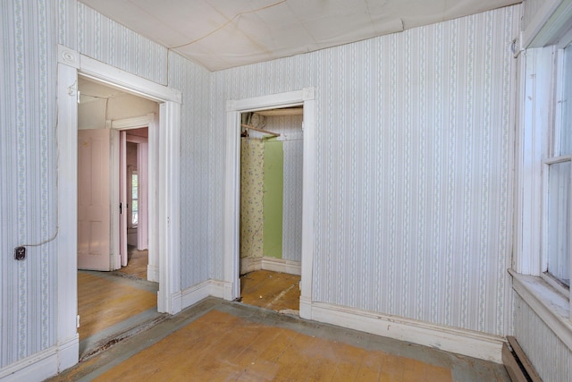 414 4th St, Winthrop, MN 55396 - empty room featuring wallpapered walls, a baseboard heating unit, and wood finished floors
