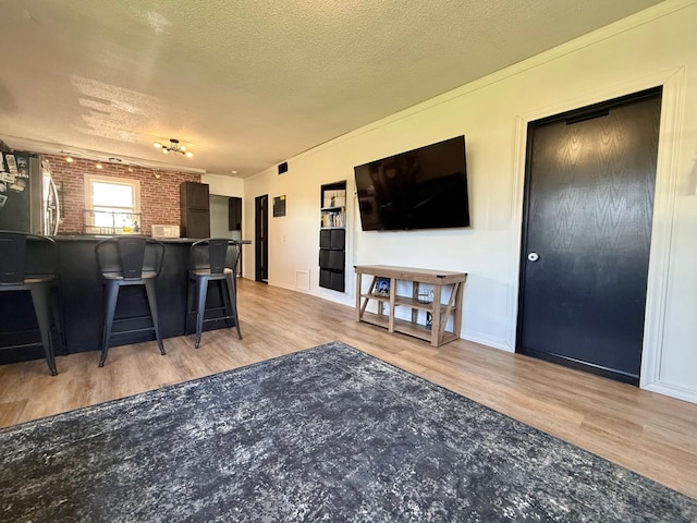513 Water Ave N, Saint Hilaire, MN 56754 - living room featuring wood finished floors, a textured ceiling, and baseboards