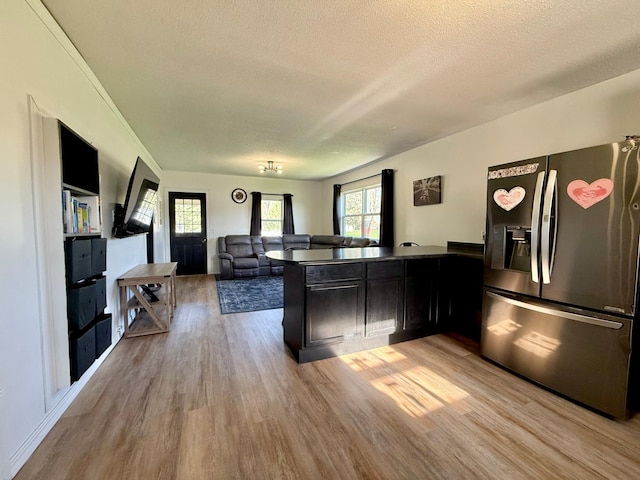 513 Water Ave N, Saint Hilaire, MN 56754 - kitchen with stainless steel refrigerator with ice dispenser, light wood-style floors, a textured ceiling, a peninsula, and open floor plan