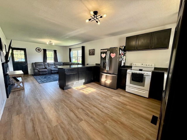 513 Water Ave N, Saint Hilaire, MN 56754 - kitchen featuring stainless steel refrigerator with ice dispenser, electric stove, open floor plan, a peninsula, and a textured ceiling