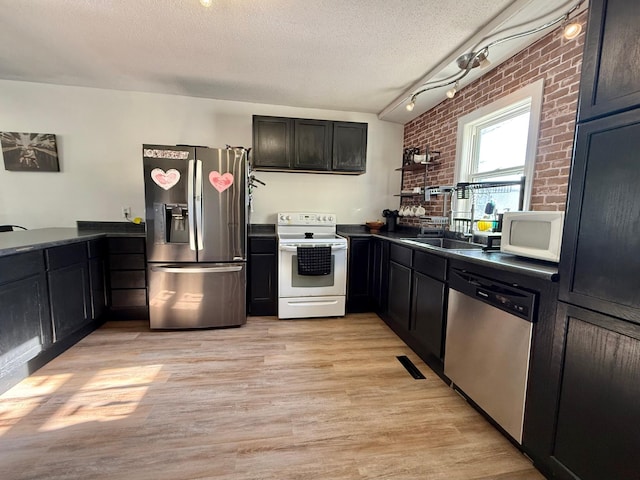 513 Water Ave N, Saint Hilaire, MN 56754 - kitchen with appliances with stainless steel finishes, dark countertops, light wood-style floors, a sink, and a textured ceiling