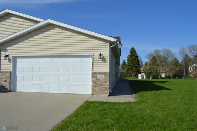 view of side of home featuring a lawn, driveway, and brick siding
