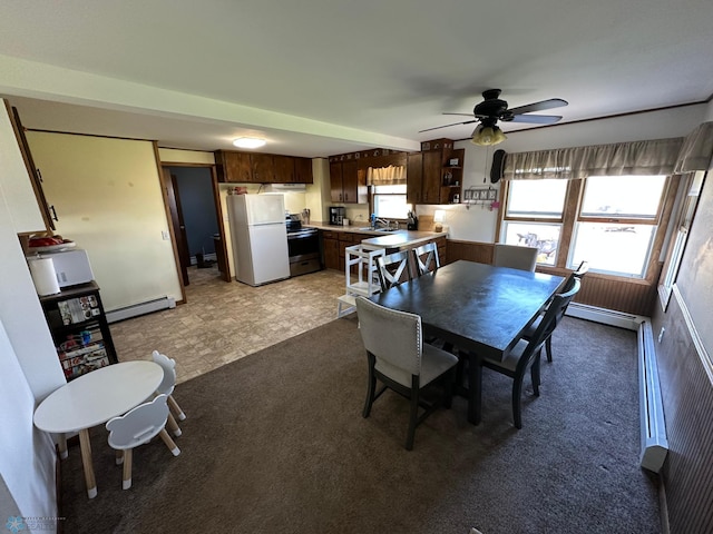 dining space featuring light carpet, a ceiling fan, and a baseboard heating unit