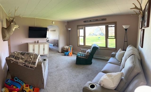 carpeted living room featuring baseboard heating, a baseboard heating unit, and arched walkways
