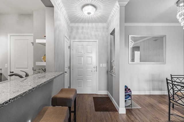 entrance foyer with wood finished floors, baseboards, and crown molding