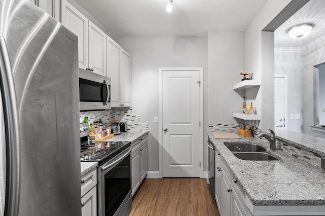 kitchen with stainless steel appliances, a sink, open shelves, dark wood finished floors, and decorative backsplash