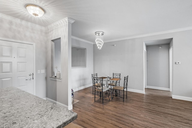 dining space with wood finished floors, baseboards, crown molding, and a chandelier