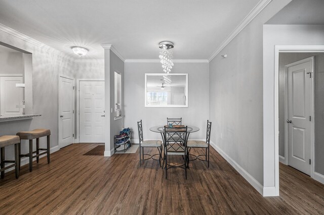 dining room featuring dark wood-style flooring, baseboards, a chandelier, and ornamental molding