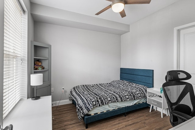 bedroom with wood finished floors, multiple windows, and baseboards