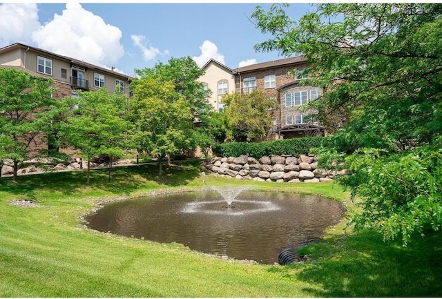view of community with a yard and a water view