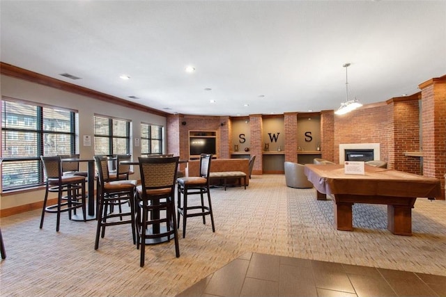 recreation room featuring a glass covered fireplace, light carpet, baseboards, recessed lighting, and crown molding