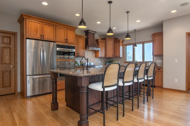 532 150th St, Alden Twp, WI 54001 - kitchen with stainless steel appliances, custom exhaust hood, brown cabinets, light wood-type flooring, and recessed lighting