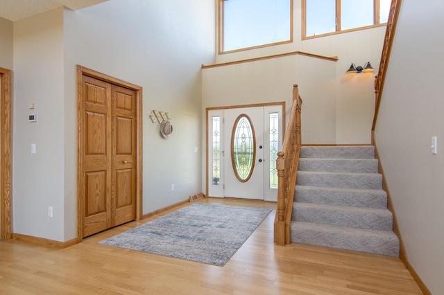 532 150th St, Alden Twp, WI 54001 - entrance foyer featuring wood finished floors, stairway, a towering ceiling, and baseboards