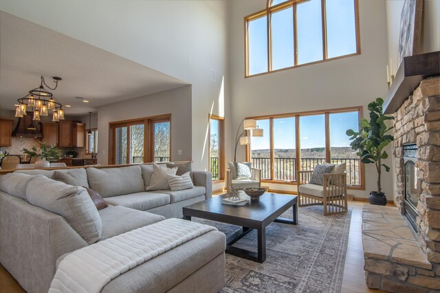 532 150th St, Alden Twp, WI 54001 - living area featuring light wood finished floors, a high ceiling, a chandelier, a stone fireplace, and a water view