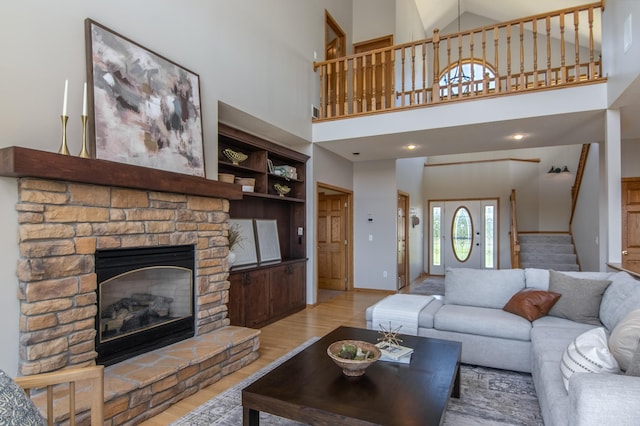 532 150th St, Alden Twp, WI 54001 - living area with wood finished floors, stairway, a fireplace, a high ceiling, and baseboards