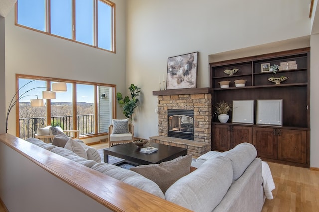532 150th St, Alden Twp, WI 54001 - living room featuring a towering ceiling, a fireplace, light wood-style floors, and healthy amount of natural light