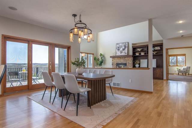 532 150th St, Alden Twp, WI 54001 - dining room with french doors, a fireplace, light wood-style flooring, a chandelier, and recessed lighting