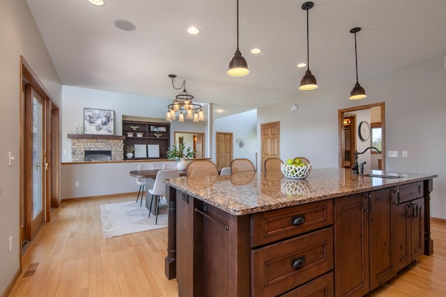 532 150th St, Alden Twp, WI 54001 - kitchen with a sink, light wood-style floors, a fireplace, decorative light fixtures, and recessed lighting