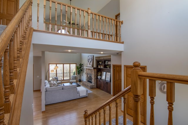 532 150th St, Alden Twp, WI 54001 - stairway with a fireplace, wood finished floors, a towering ceiling, and baseboards