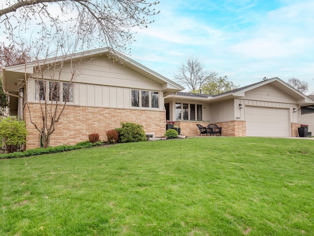 3509 Coolidge St NE, Saint Anthony, MN 55418 - view of front facade featuring brick siding, a garage, and a front yard