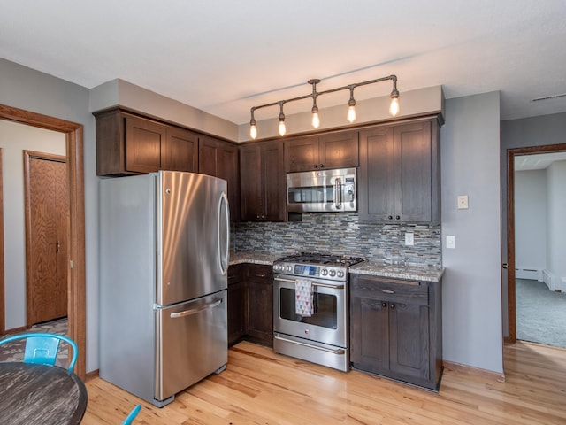 3509 Coolidge St NE, Saint Anthony, MN 55418 - kitchen featuring appliances with stainless steel finishes, dark brown cabinetry, light wood-style flooring, and backsplash