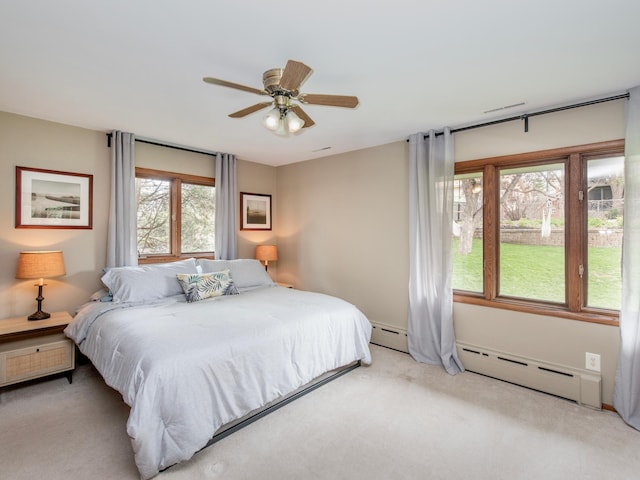 3509 Coolidge St NE, Saint Anthony, MN 55418 - bedroom with light colored carpet, a baseboard radiator, and ceiling fan