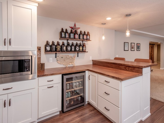 3509 Coolidge St NE, Saint Anthony, MN 55418 - indoor dry bar with stainless steel microwave, wine cooler, dark wood-style flooring, decorative light fixtures, and recessed lighting