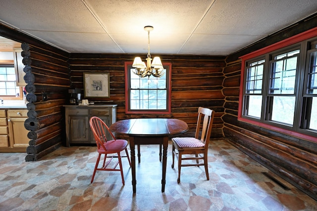 9262 Park Ave, Solon Springs, WI 54873 - dining space with log walls, a chandelier, plenty of natural light, and light stone finish flooring