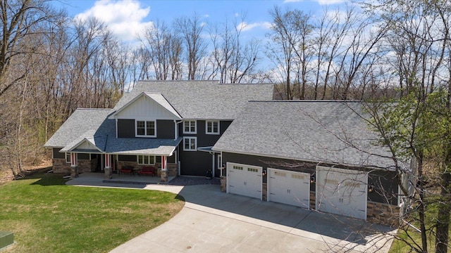 701 Chalupsky Ave SE, New Prague, MN 56071 - view of front of home featuring stone siding, roof with shingles, concrete driveway, a front lawn, and covered porch