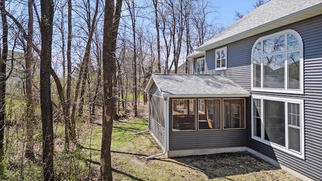 701 Chalupsky Ave SE, New Prague, MN 56071 - view of side of property with a sunroom, a shingled roof, and a yard