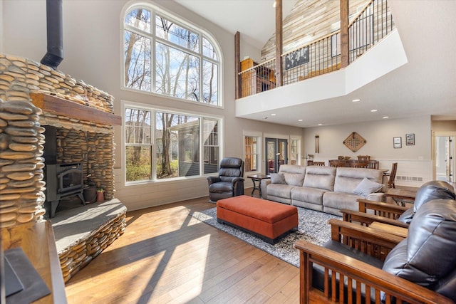 701 Chalupsky Ave SE, New Prague, MN 56071 - living area with a wood stove, wood-type flooring, and a towering ceiling