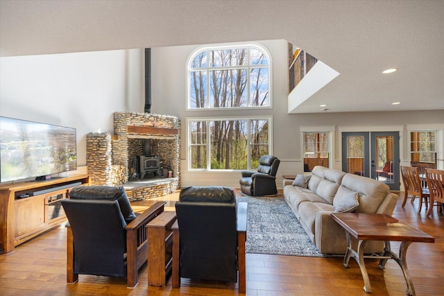 701 Chalupsky Ave SE, New Prague, MN 56071 - living room featuring a wood stove, hardwood / wood-style floors, recessed lighting, and a high ceiling