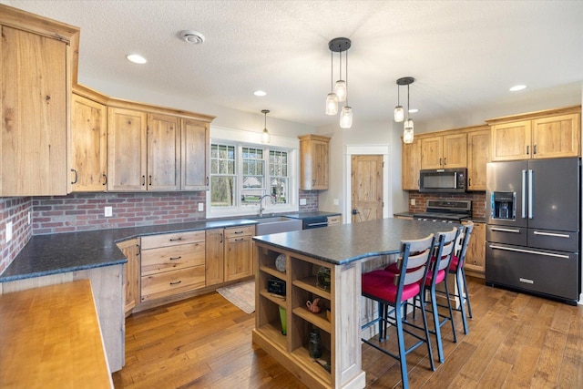 701 Chalupsky Ave SE, New Prague, MN 56071 - kitchen featuring stainless steel appliances, dark countertops, a sink, tasteful backsplash, and recessed lighting