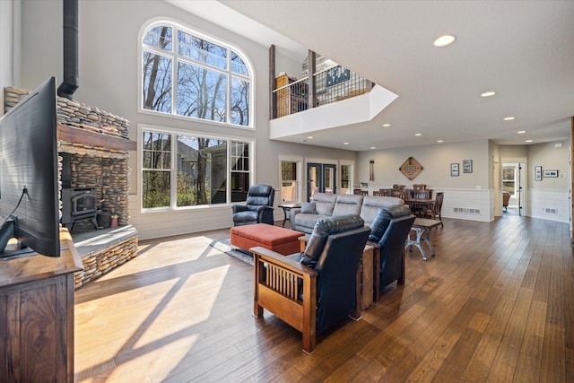 701 Chalupsky Ave SE, New Prague, MN 56071 - living room with a wood stove, wainscoting, hardwood / wood-style flooring, a towering ceiling, and recessed lighting