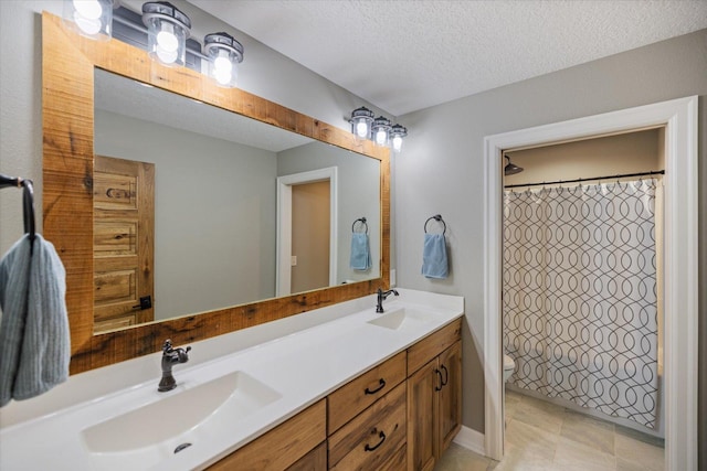 701 Chalupsky Ave SE, New Prague, MN 56071 - bathroom featuring toilet, double vanity, a textured ceiling, and a shower with curtain