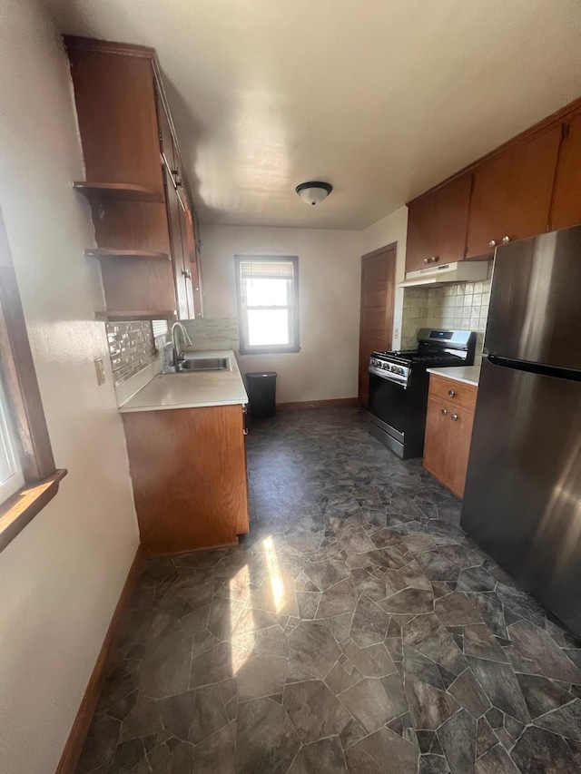 1008 4th St E, Saint Paul, MN 55106 - kitchen with appliances with stainless steel finishes, a sink, backsplash, dark stone finish floors, and brown cabinets