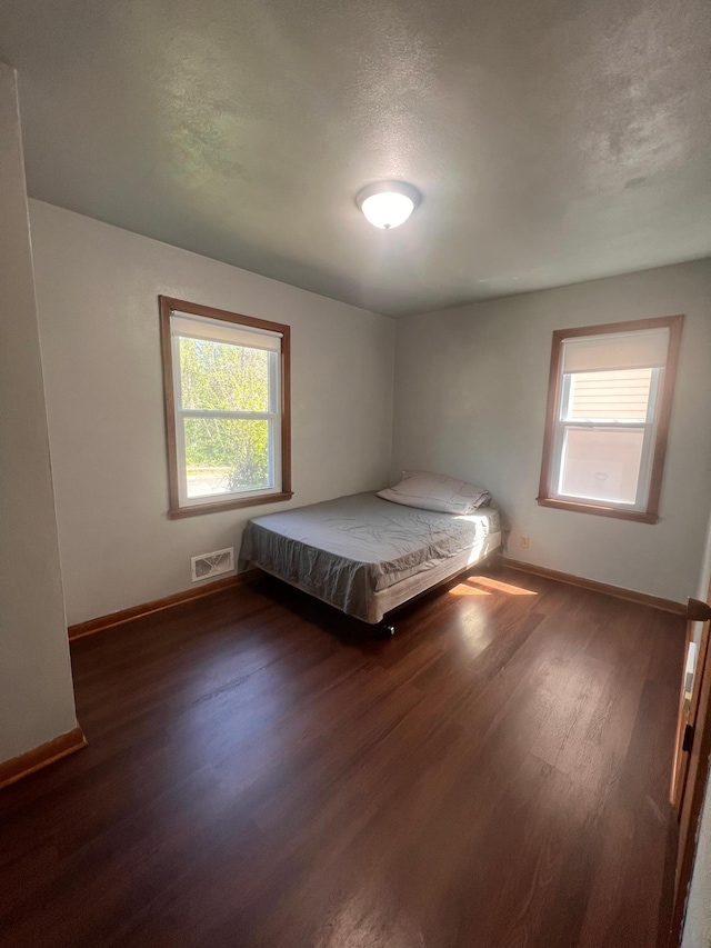 1008 4th St E, Saint Paul, MN 55106 - bedroom with multiple windows, wood finished floors, and baseboards