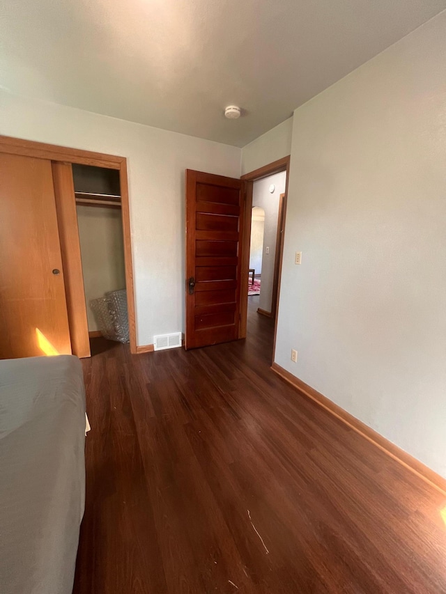 1008 4th St E, Saint Paul, MN 55106 - unfurnished bedroom with wood finished floors, baseboards, and a closet