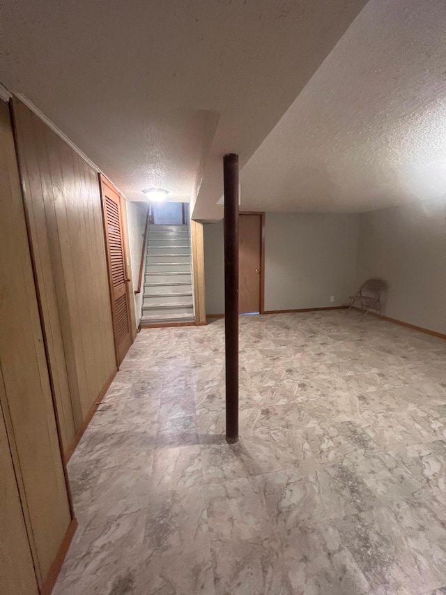 1008 4th St E, Saint Paul, MN 55106 - finished basement featuring a textured ceiling, stairs, wood walls, and baseboards
