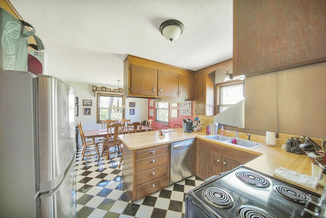 1418 345th Ave, Frederic, WI 54837 - kitchen with stainless steel appliances, brown cabinetry, dark flooring, a sink, and light countertops