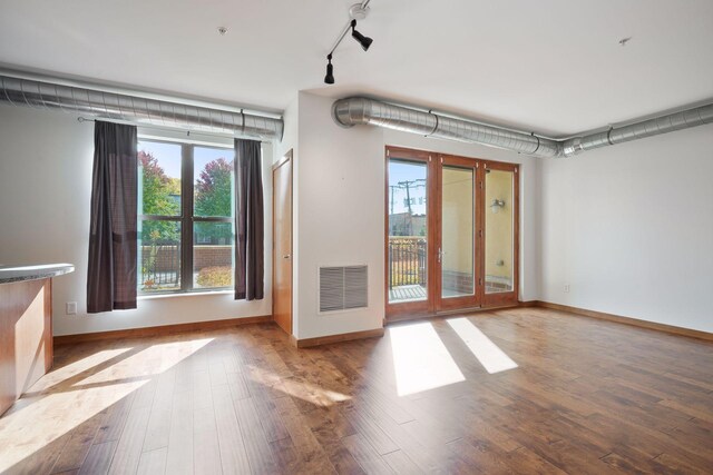 interior space featuring wood finished floors, baseboards, track lighting, and french doors