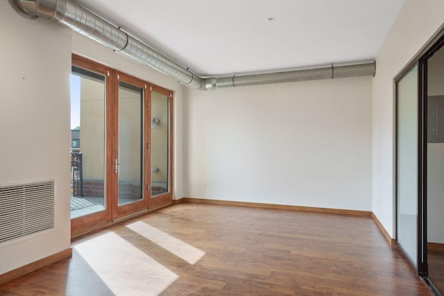 empty room with french doors, wood finished floors, and baseboards