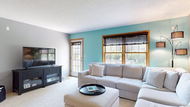 living area featuring light carpet, a textured ceiling, and baseboards