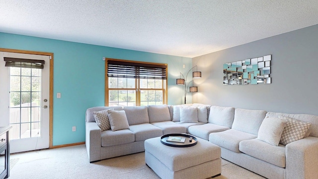 carpeted living area featuring a textured ceiling and baseboards