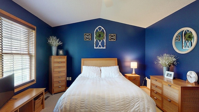 bedroom featuring vaulted ceiling, carpet, baseboards, and a ceiling fan