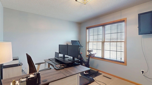 office area featuring carpet floors, baseboards, and a textured ceiling