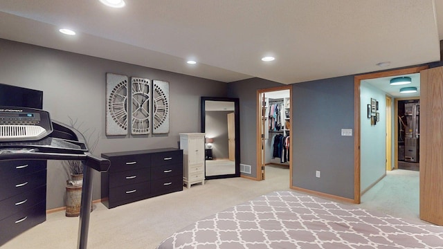 bedroom featuring light carpet, a walk in closet, baseboards, a closet, and recessed lighting